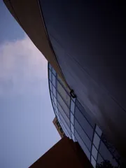 A building of multiple curves on a strange angle, with satisfying texture and tonal gradients.